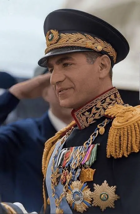 His Majesty, the Shah of Iran in a dark ornate military uniform with gold embroidery and medals wears a peaked cap — a public domain photograph from The Shah of Iran archive documenting the Pahlavi era.