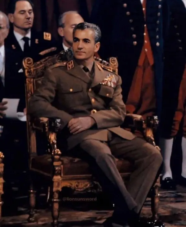 His Majesty, the Shah of Iran in a military uniform sits in an ornate gold chair while other uniformed men stand behind him — a public domain photograph from The Shah of Iran archive documenting the Pahlavi era.