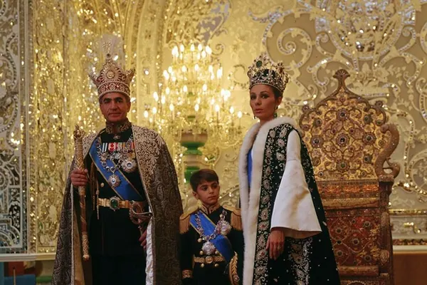 His Majesty, the Shah of Iran, woman, and boy in ornate royal attire stand together in a gold decorated room — a public domain photograph from The Shah of Iran archive documenting the Pahlavi era.