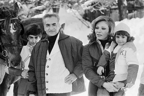 His Majesty, the Shah of Iran, woman, and child stand together in a snowy outdoor setting next to a horse — a public domain photograph from The Shah of Iran archive documenting the Pahlavi era.