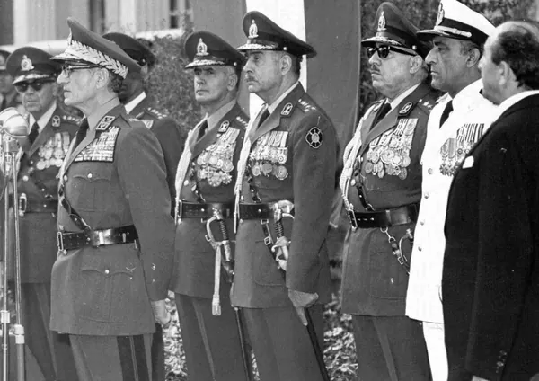 Men in formal military uniforms with medals and peaked caps stand in a line outdoors — a public domain photograph from The Shah of Iran archive documenting the Pahlavi era.