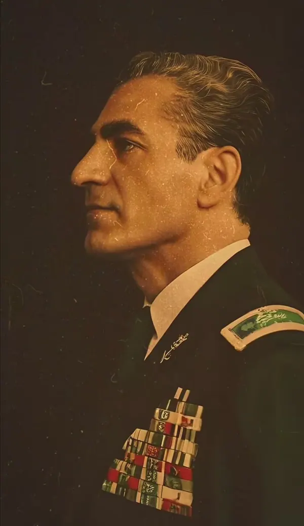 His Majesty, the Shah of Iran in a dark military uniform with medals and shoulder boards poses in profile — a public domain photograph from The Shah of Iran archive documenting the Pahlavi era.