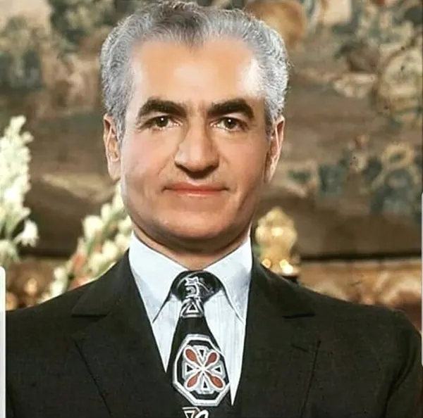 His Majesty, the Shah of Iran in a dark suit and patterned tie poses for a head-and-shoulders portrait — a public domain photograph from The Shah of Iran archive documenting the Pahlavi era.