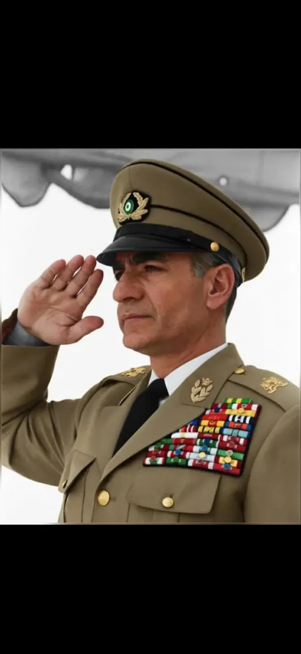 His Majesty, the Shah of Iran in a tan military uniform with medals salutes while wearing a peaked cap — a public domain photograph from The Shah of Iran archive documenting the Pahlavi era.