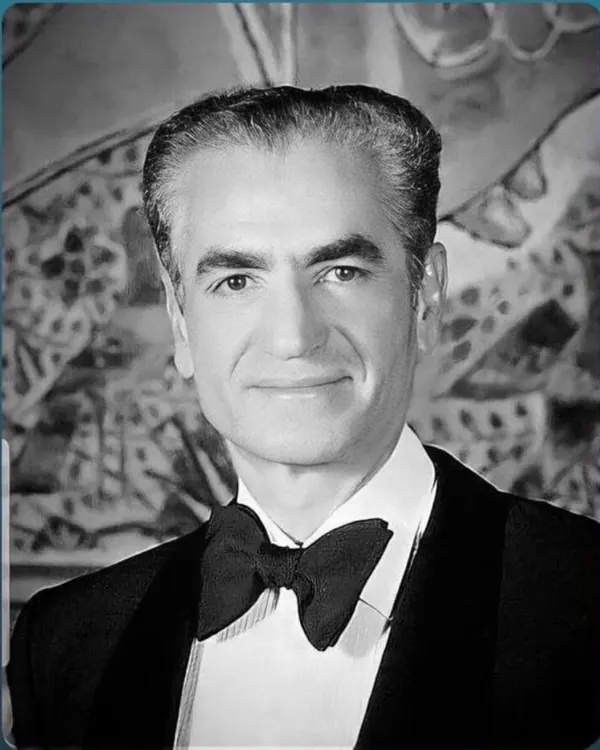 His Majesty, the Shah of Iran in a tuxedo and bow tie poses for a portrait against an abstract background — a public domain photograph from The Shah of Iran archive documenting the Pahlavi era.