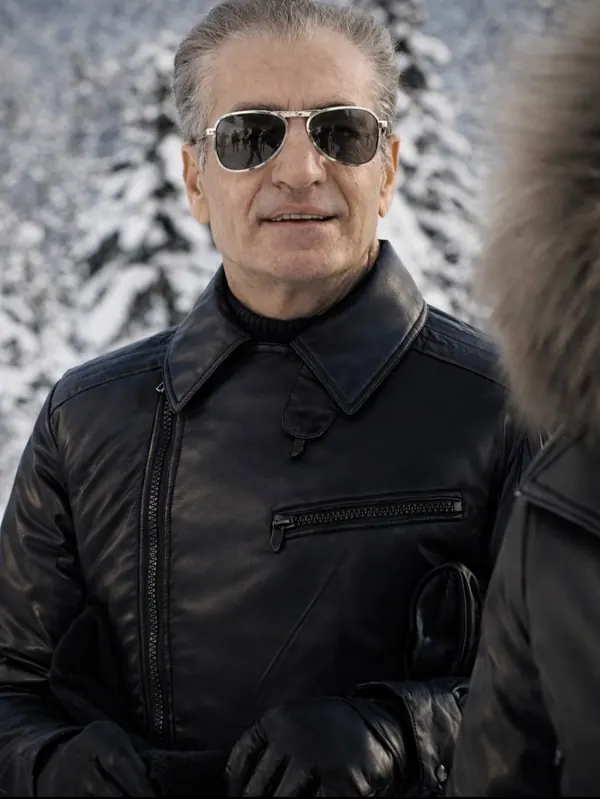His Majesty, the Shah of Iran wearing sunglasses and a black leather jacket stands against a snowy forest background — a public domain photograph from The Shah of Iran archive documenting the Pahlavi era.