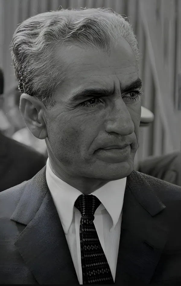 His Majesty, the Shah of Iran with grey hair wears a suit and tie in a close-up portrait — a public domain photograph from The Shah of Iran archive documenting the Pahlavi era.