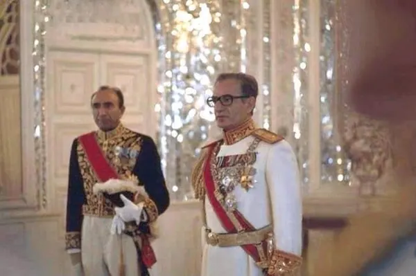 His Majesty, the Shah of Iran, and others in ornate military uniforms with sashes stand before a mirrored wall in a formal room — a public domain photograph from The Shah of Iran archive documenting the Pahlavi era.