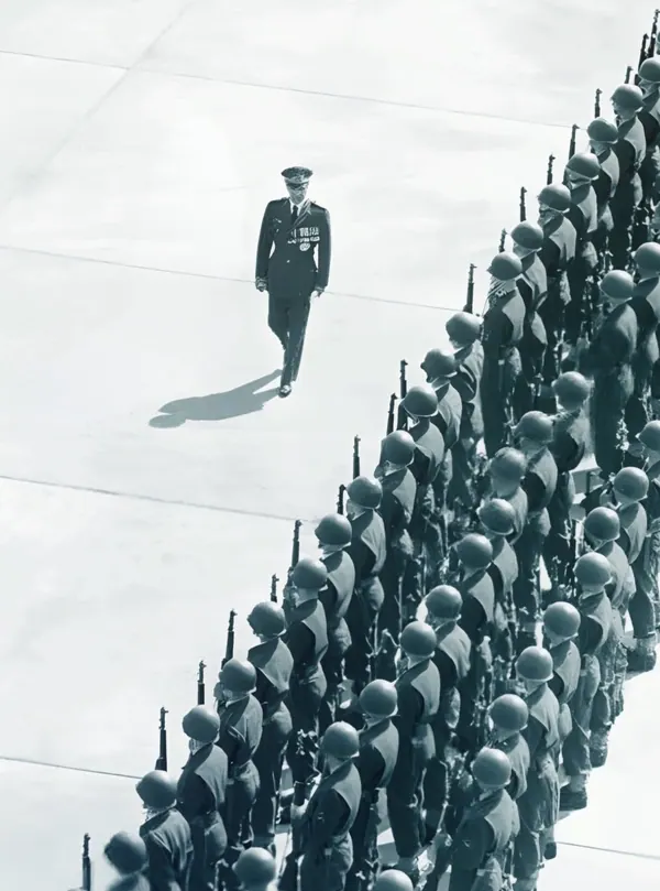His Majesty, the Shah of Iran, in uniform, walks past a long line of soldiers standing at attention with rifles — a public domain photograph from The Shah of Iran archive documenting the Pahlavi era.