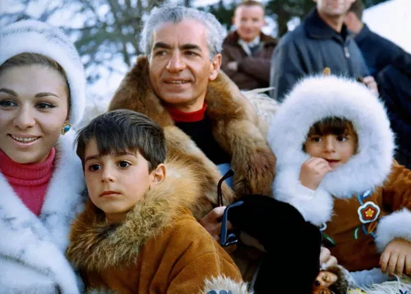 Farah Pahlavi, Empress of Iran, His Majesty, and two children wear heavy fur clothing while posing outdoors in a snowy setting — a public domain photograph from The Shah of Iran archive documenting the Pahlavi era.